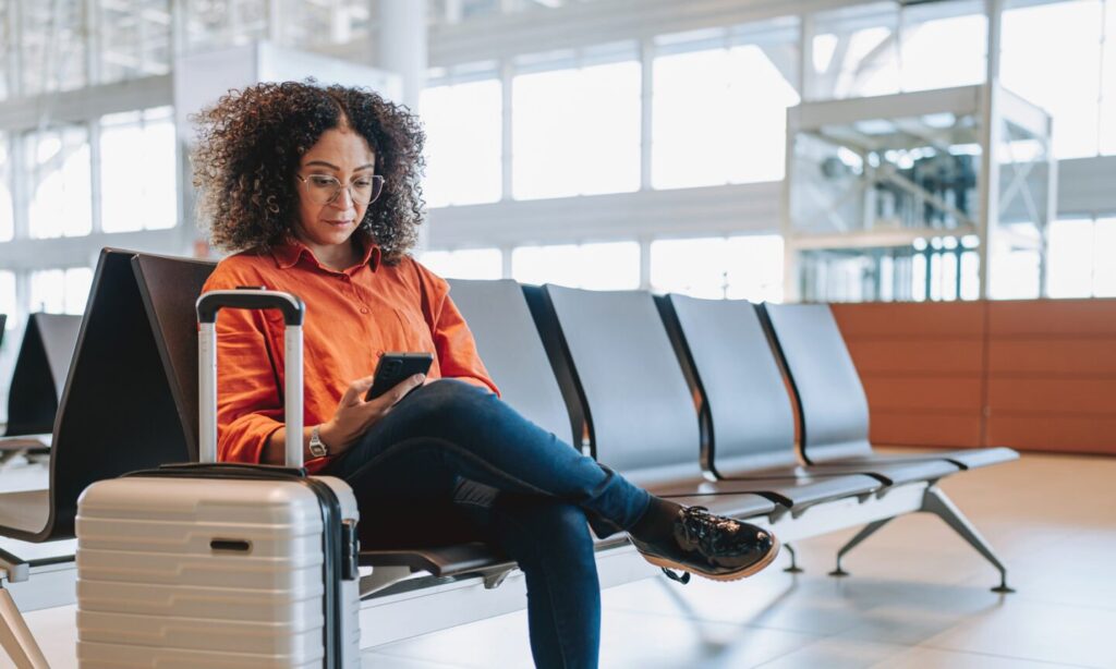 What Travelers Need to Know About the FAA Flight Reductions Person, Sitting, Electronics